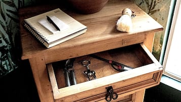 A wooden nightstand with a lamp, a notebook, and keys.