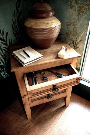 A wooden nightstand with a lamp, a notebook, and keys.