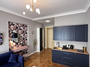 A modern kitchen with dark cabinets, a wooden countertop, and a built-in sink. - The Spiski Palace (Kraków)