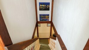 Een trap met houten leuningen en een bekleed landingsvlak.