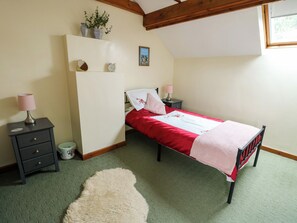 A bedroom with a bed, bedside tables, a wardrobe, a small rug, and a window.