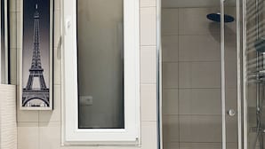 Ein Badezimmer mit einer Duschkabine, einer Toilette und einem Waschbecken.