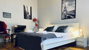 Ein modernes Hotelzimmer mit Bett, Nachttischen, einem Schreibtisch mit Stuhl und Bildern an den Wänden.