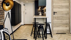 A modern kitchen with a coffee machine, black bar stools, and a large floor lamp. - Apartment Premium Jacuzzi for couples, Old Town I, Starowiślna (Kraków)