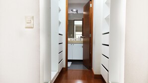 A narrow hallway with a wooden floor leading to a bathroom with a sink and mirror. - Beautiful 2,150 sq. ft. 3BR apartment in upscale Chacarilla (Lima)