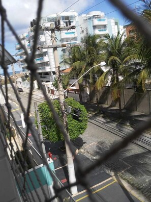 A residential area with modern buildings, a street with palm trees, and visible electrical infrastructure. - Ape da Praia - Frauches (Cabo Frio)