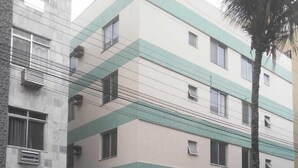Un immeuble à plusieurs étages, doté d’une entrée fermée par un portail, d’une enseigne indiquant « BLAUCHES 10 » et d’un palmier situé à proximité.