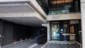 Een moderne gevel met het nummer '3001' boven de deur, een trap en een betegelde vloer.