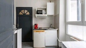 Et lille køkken med mikroovn, minikøleskab og vask.