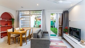 Un salon moderne avec un canapé, une table à manger et un téléviseur.