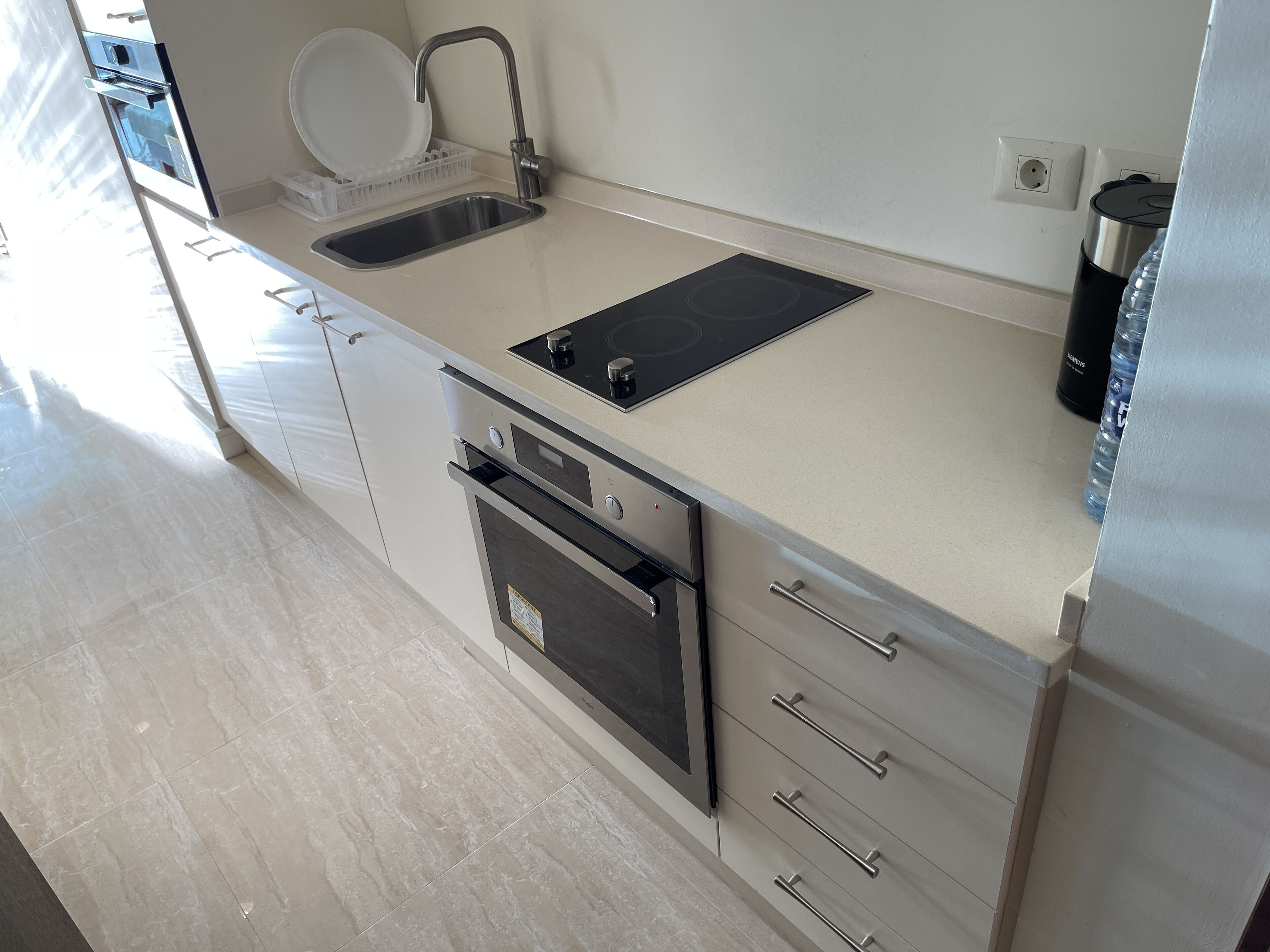 Una cocina moderna con pileta, estufa y horno integrado.