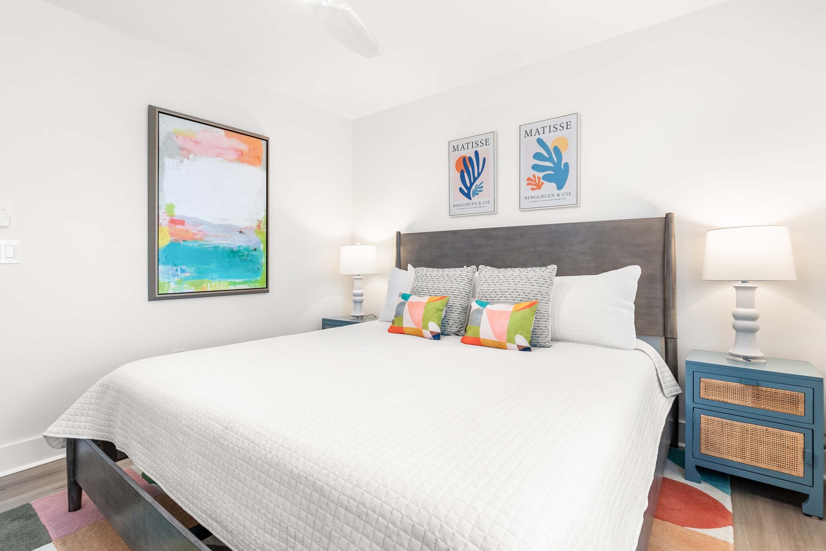 Una camera da letto ordinata con un letto grande, due comodini e decorazioni a parete.