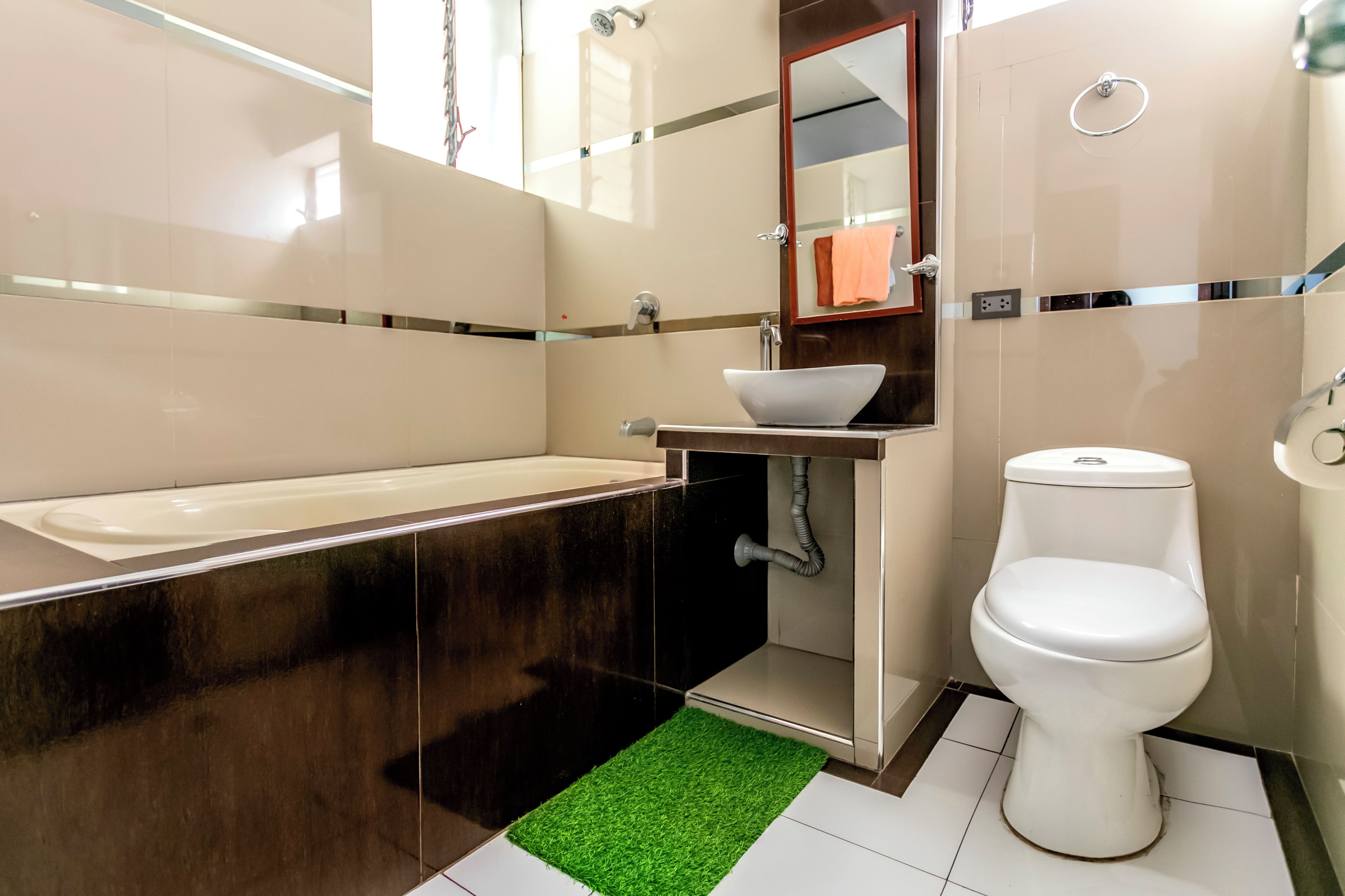 Et moderne badeværelse med badekar, vask og toilet.