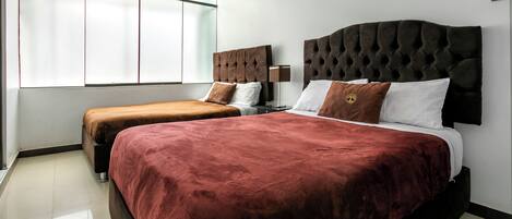 Quarto de hotel com duas camas, uma janela ampla e design moderno.