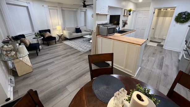 Uma sala de estar moderna com um sofá, mesa de centro e um espaço de jantar com mesa e cadeiras de madeira.