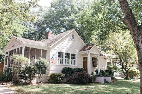 A single-story house with a porch, a chimney, and a flag. - Walk to Marietta Square -The Cottage on Maple (Marietta)