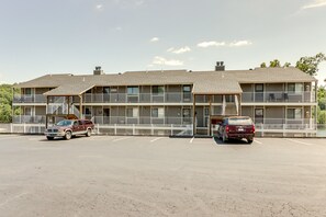 A multi-story motel with a parking lot, featuring a two-story structure with balconies and a flat roof. - Walk to Pool + Lake: Cozy Osage Beach Condo (Osage Beach)