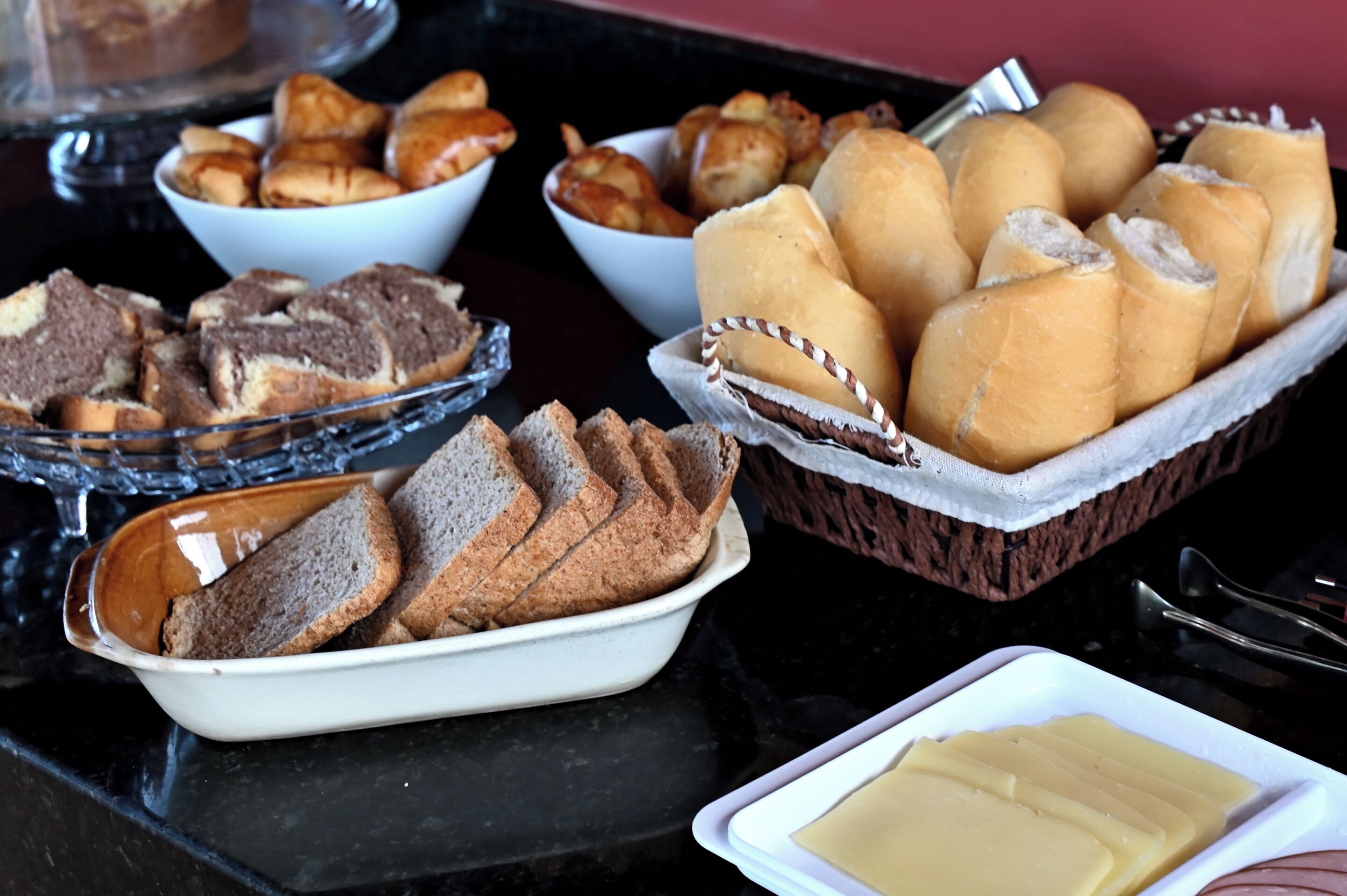 Een buffettafel met diverse gebakken producten, zoals brood, gebak en broodjes.