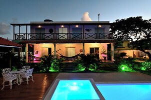 Una piscina al aire libre, sombrillas, sillones reclinables de piscina