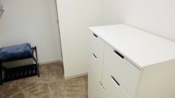 A room with a white desk, a chair, and a carpeted floor.