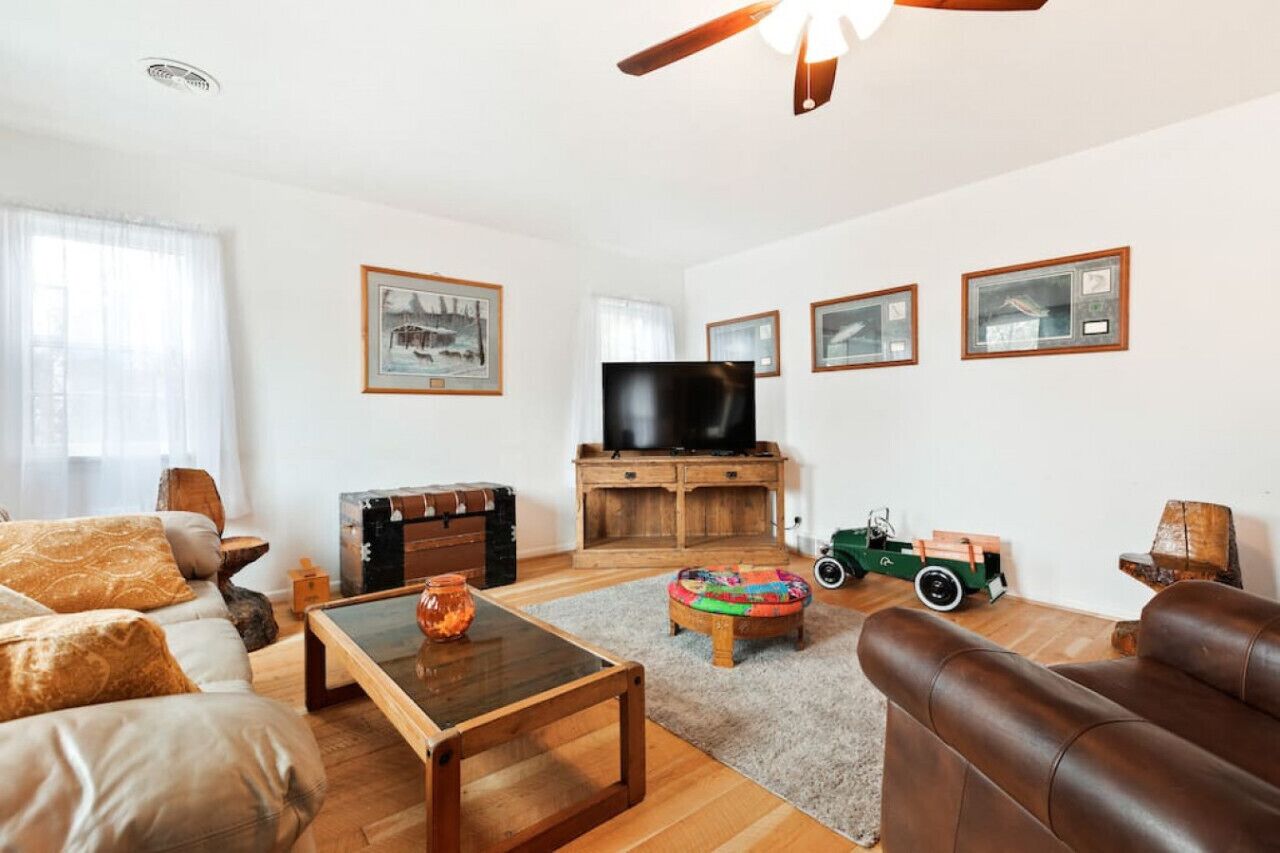 A living room with a sofa, coffee table, TV, and a small wooden cabinet.