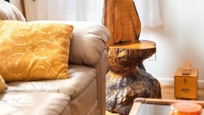 Ein gemütliches Zimmer mit einer Couch, einer Holzskulptur und einem kleinen Tisch.