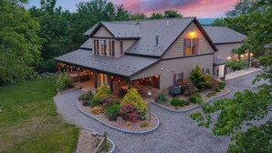 Une maison à deux étages dotée d’un patio couvert et d’un jardin aménagé.