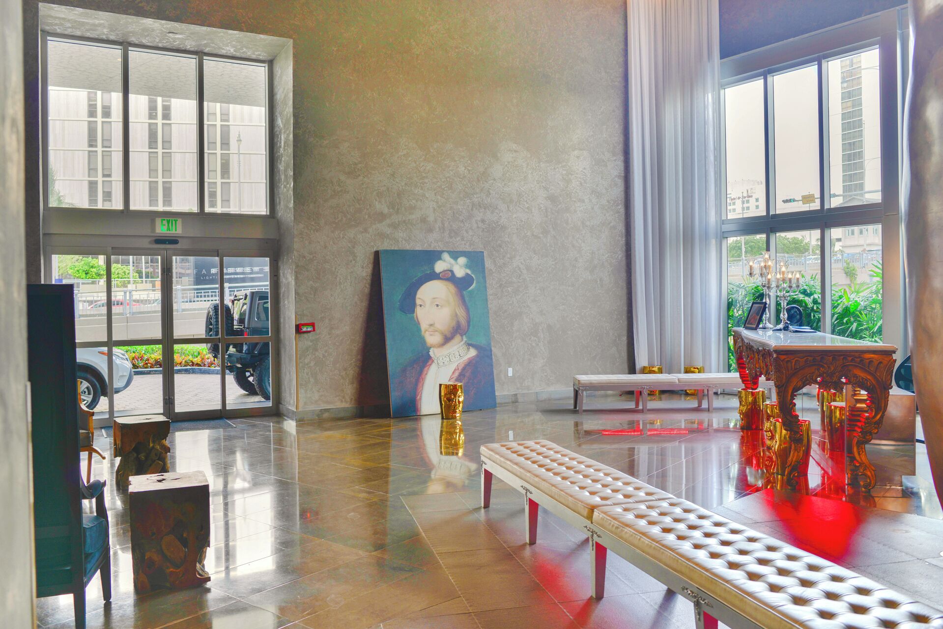 Eine Lobby mit einem großen Gemälde, einer Bank und einem Tisch mit Kerzen.