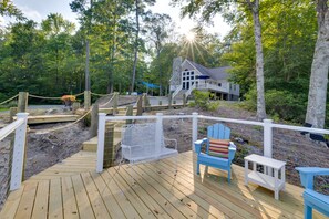 A wooden deck with a white fence, a blue chair, and a small table. - Waterfront Hartfield Vacation Rental w/ Dock! (Hartfield)