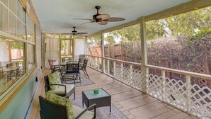 A covered patio with wicker furniture, ceiling fans, and a view of a backyard. - Lake Wales Vacation Rental w/ Screened-In Porch! (Lake Wales)