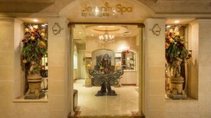 Der Eingang des Serenity Spa by Wesigate, mit einem prächtigen Chandelier, klassischen Statuen und aufwendigen Blumenarrangements.