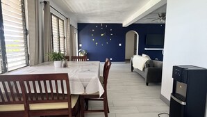 A dining area with a table and chairs, a water dispenser, and a ceiling fan. - Tropical Oasis 🇻🇮Stunning ocean view, minutes drive to Brewers Beach!🇻🇮🏝 (St Thomas)