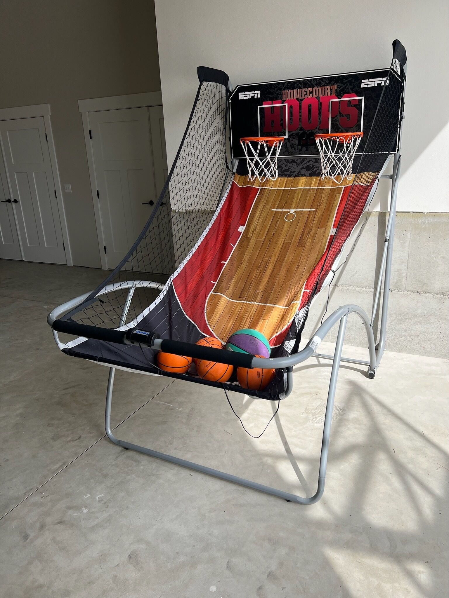 A portable basketball court with a hoop and backboard, featuring the text "ESPN Howie Court Hoops."