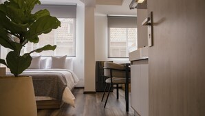 A modern bedroom with a bed, bedside table, and a large potted plant. - 5Q House Quinta Camacho (Bogotá)