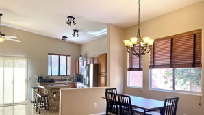 Una cocina amplia con armarios de madera, una isla central y un comedor con mesa y sillas.