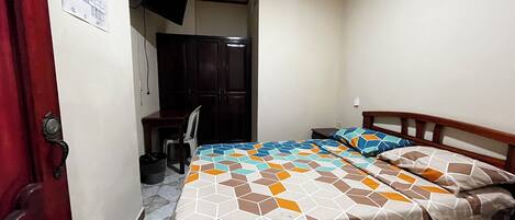 Un dormitorio con cama, escritorio, silla y armario.