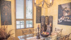 A dining area with a glass table, metal chairs, a chandelier, and decorative wall art. - LOCATION! 100ft from PRIVATE beach access (Santa Rosa Beach)