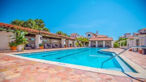 A swimming pool with lounge chairs and potted plants, surrounded by buildings with tiled roofs. - LOCATION! 100ft from PRIVATE beach access (Santa Rosa Beach)