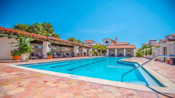 A swimming pool with lounge chairs and potted plants, surrounded by buildings with tiled roofs. - LOCATION! 100ft from PRIVATE beach access (Santa Rosa Beach)