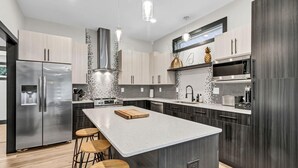 Eine moderne Küche mit einer zentralen Kochinsel, Edelstahlgeräten und einem minimalistischen Design.