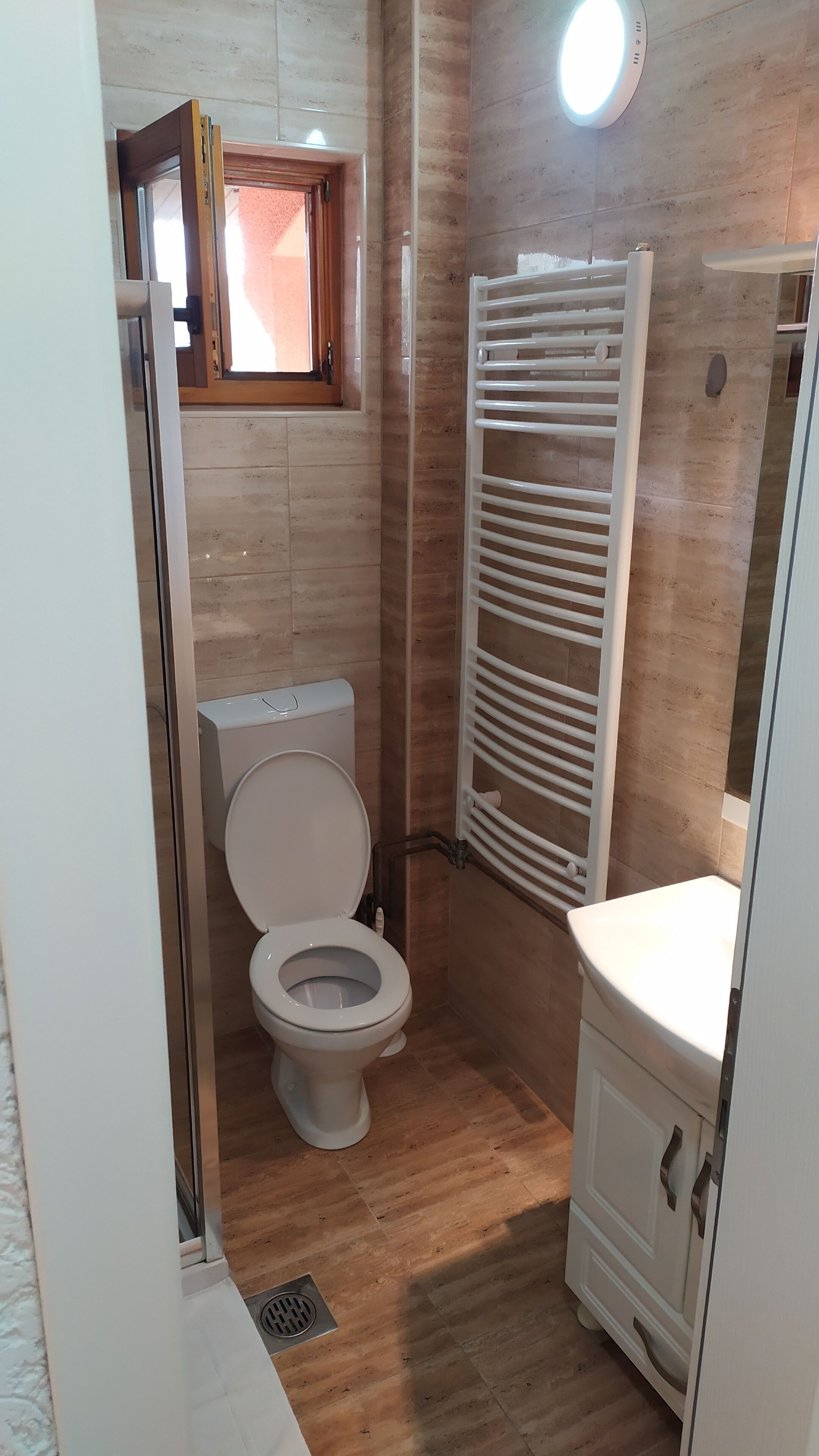 Ein kleines Badezimmer mit Toilette, Waschbecken und Handtuchhalter.