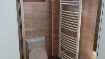 Ein kleines Badezimmer mit Toilette, Waschbecken und Handtuchhalter.