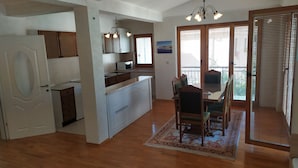 A spacious kitchen with a central island, wooden cabinets, and a dining area with a table and chairs.