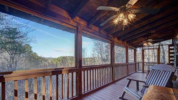A wooden deck with a railing, a ceiling fan, and a table with chairs. - Amy's Blue Ridge Mtn & Starlight View (Ellijay)