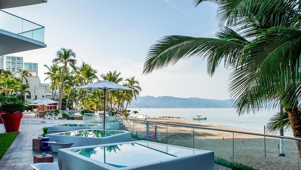 A rooftop pool area with clear views of the beach and ocean.