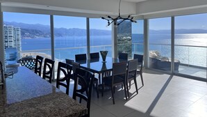 A spacious dining area with a view of the sea and mountains.