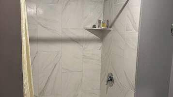 Kombinasi shower/bathtub, pancuran hujan, pengering rambut, dan handuk