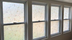 A row of windows with frosted glass and a tree pattern. - 
Maple Street Cottage is the perfect couple’s retreat. (Lake)