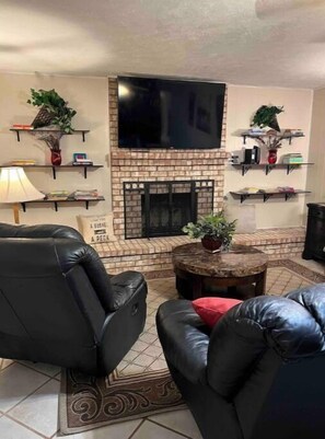Smart TV, chimenea, libros y monitor de computadora 