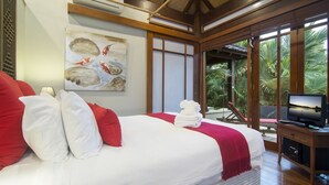 A hotel room with a large bed, a painting on the wall, a TV, and a view of palm trees.